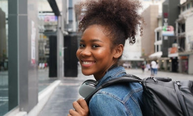 Woman with their head outside a train window, posing for a picture with a scenic mountain range in the background