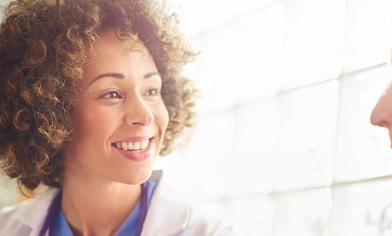 Female doctor smiling and talking to an elderly female patient