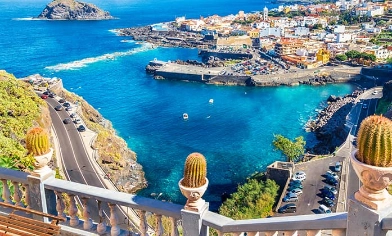 Elevated view of small coastal town in Canary Islands surrounded by blue waters